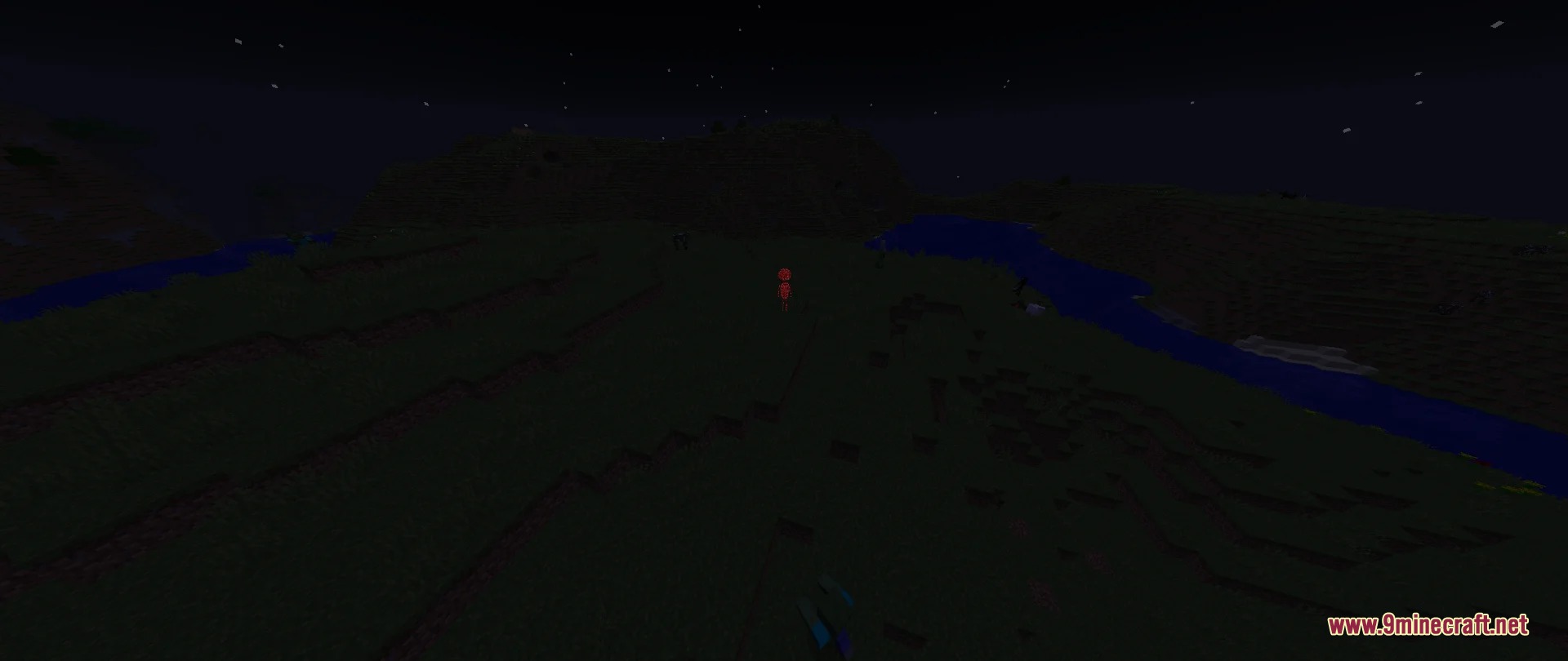 A small glowing red entity stands on a dark grassy hill at night