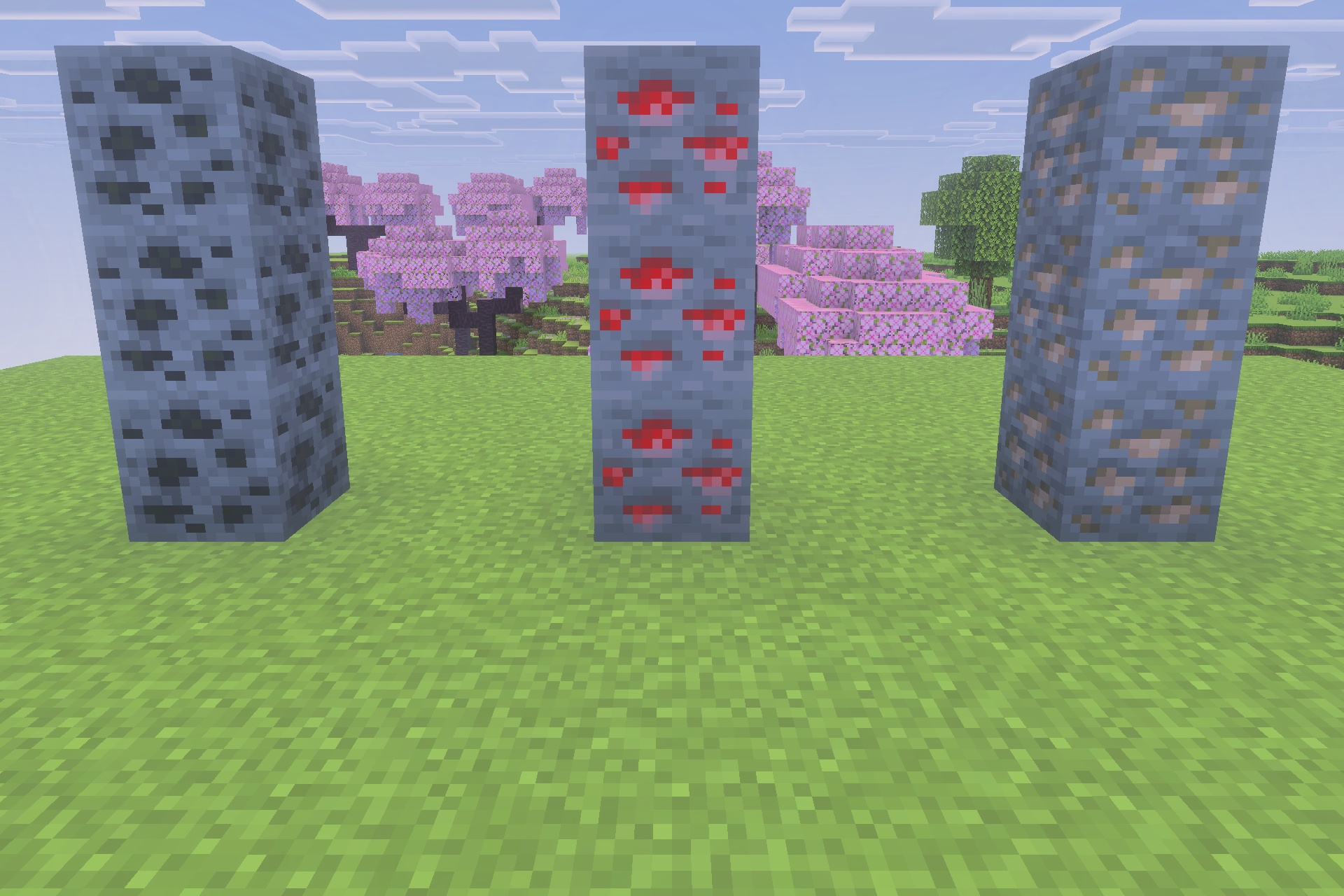 Three pillars of Minecraft ores standing on grass with cherry blossom trees behind