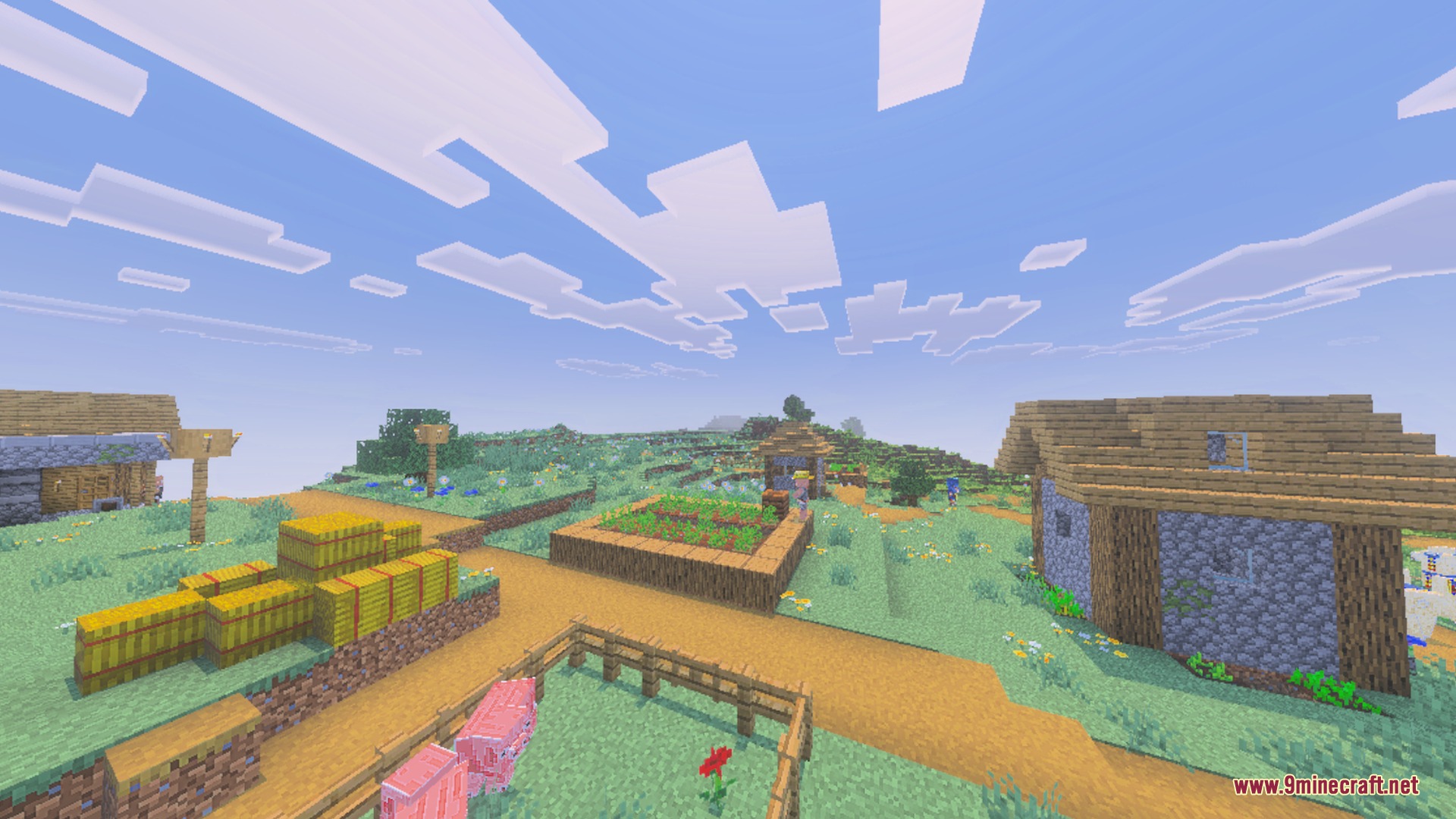 A peaceful Minecraft village featuring wooden houses hay bales and a pig pen