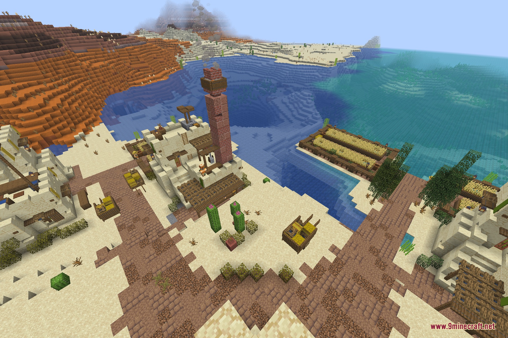 A tall brick tower stands next to a desert house and farm