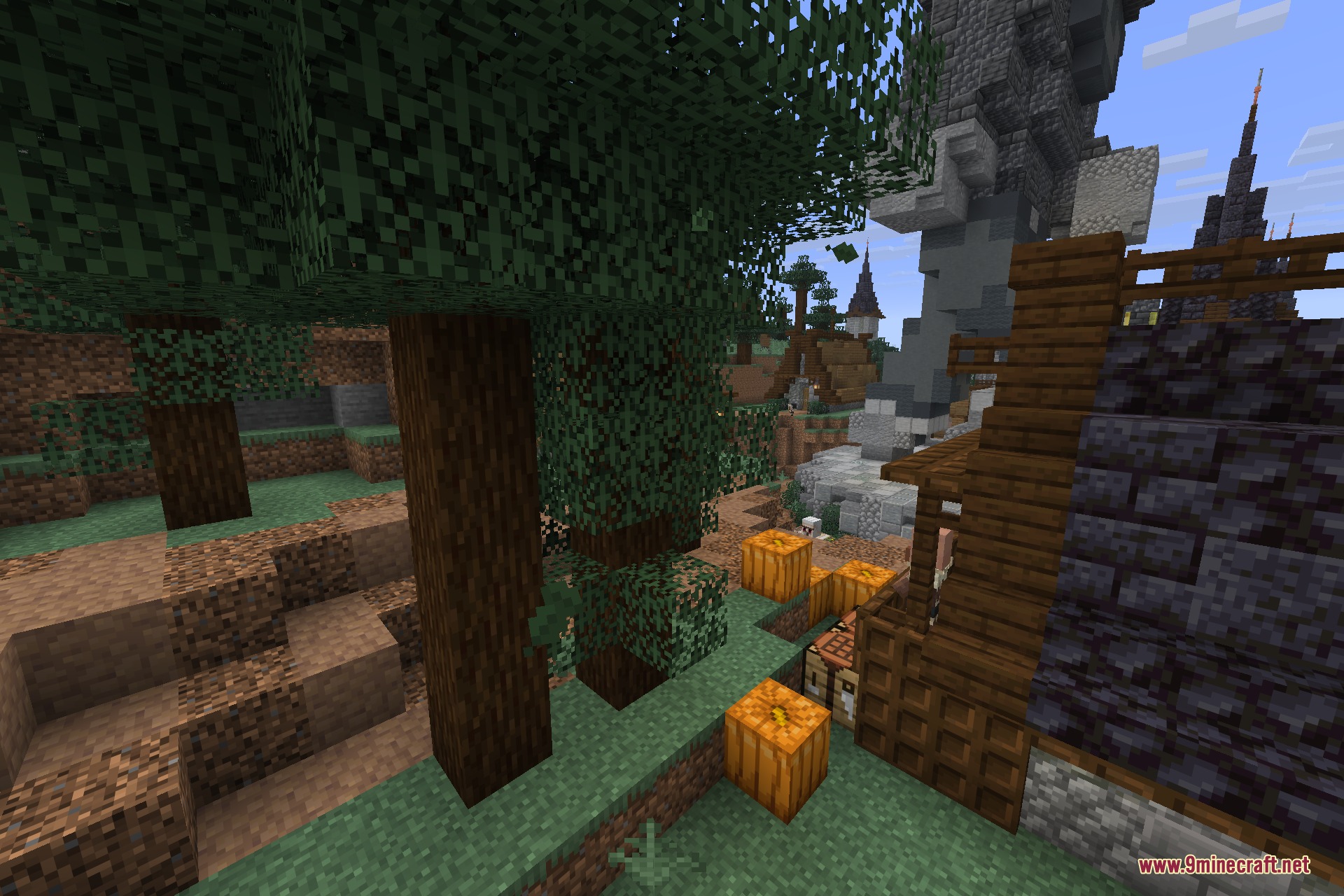 A tall stone tower stands in a detailed village area with pumpkins
