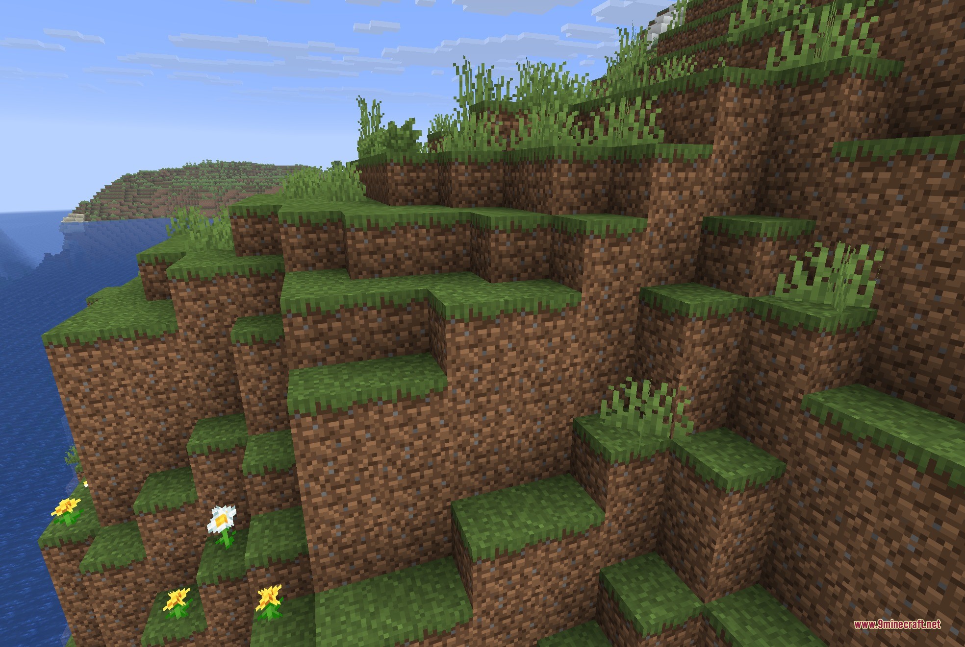 JackFredLib 9minecraft Mod Screenshot 2 A steep cliffside made of dirt and grass blocks with small wild flowers