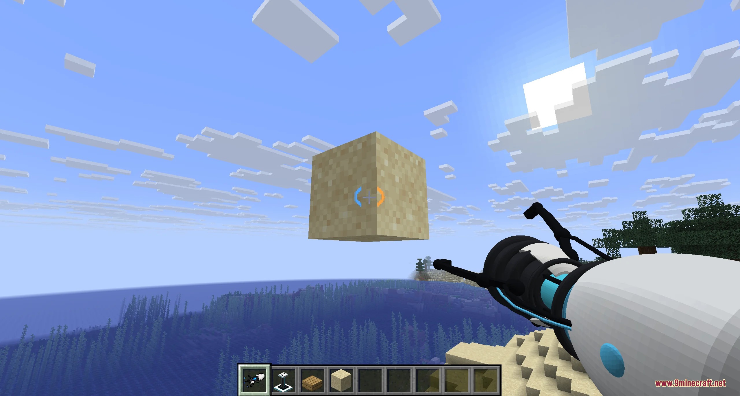 Player using a portal gun to hold a sand block over the ocean