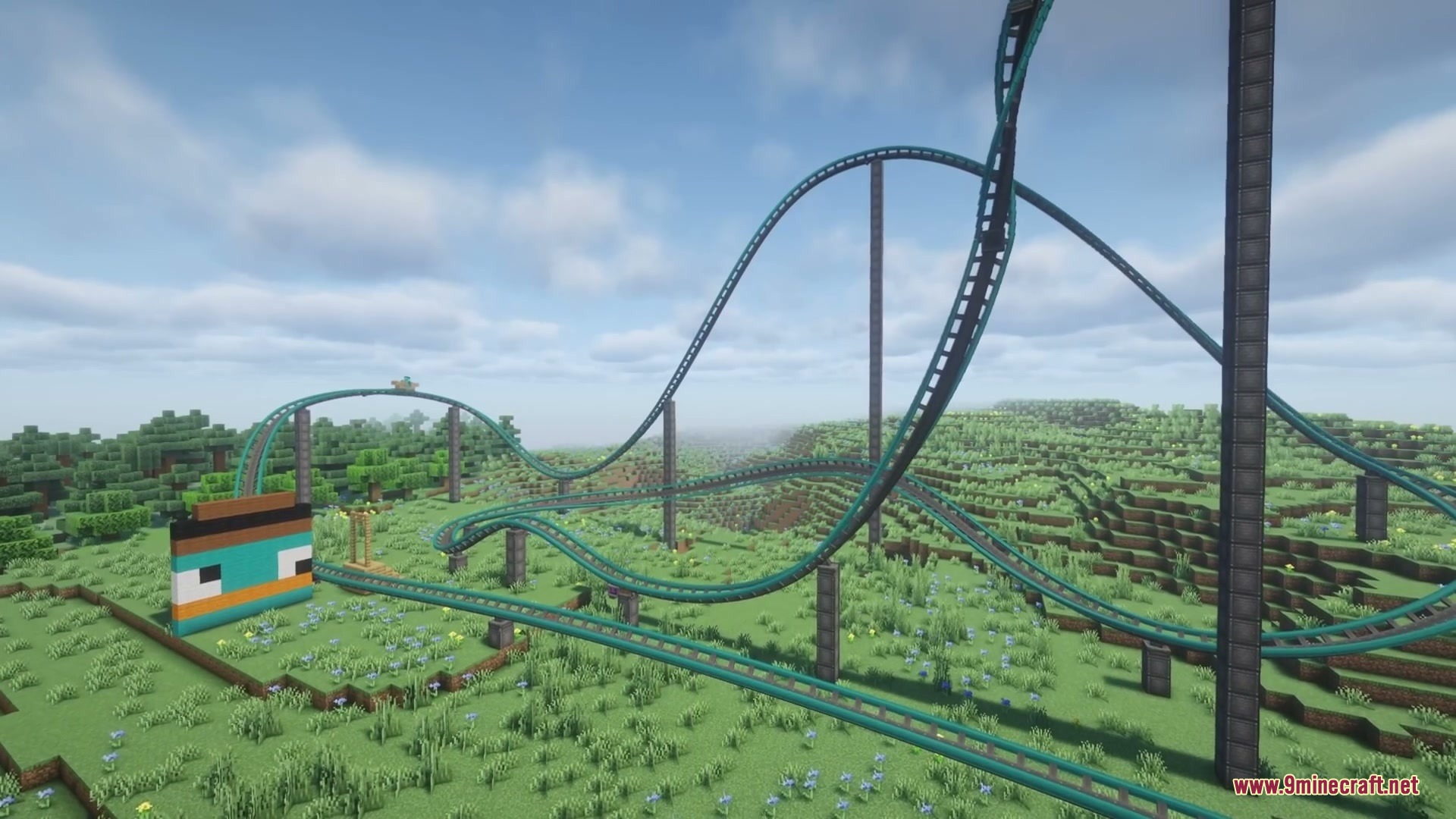 Kinetic Rail Rush Mod Screenshot 1 Teal roller coaster tracks with loops winding through a vast green Minecraft landscape