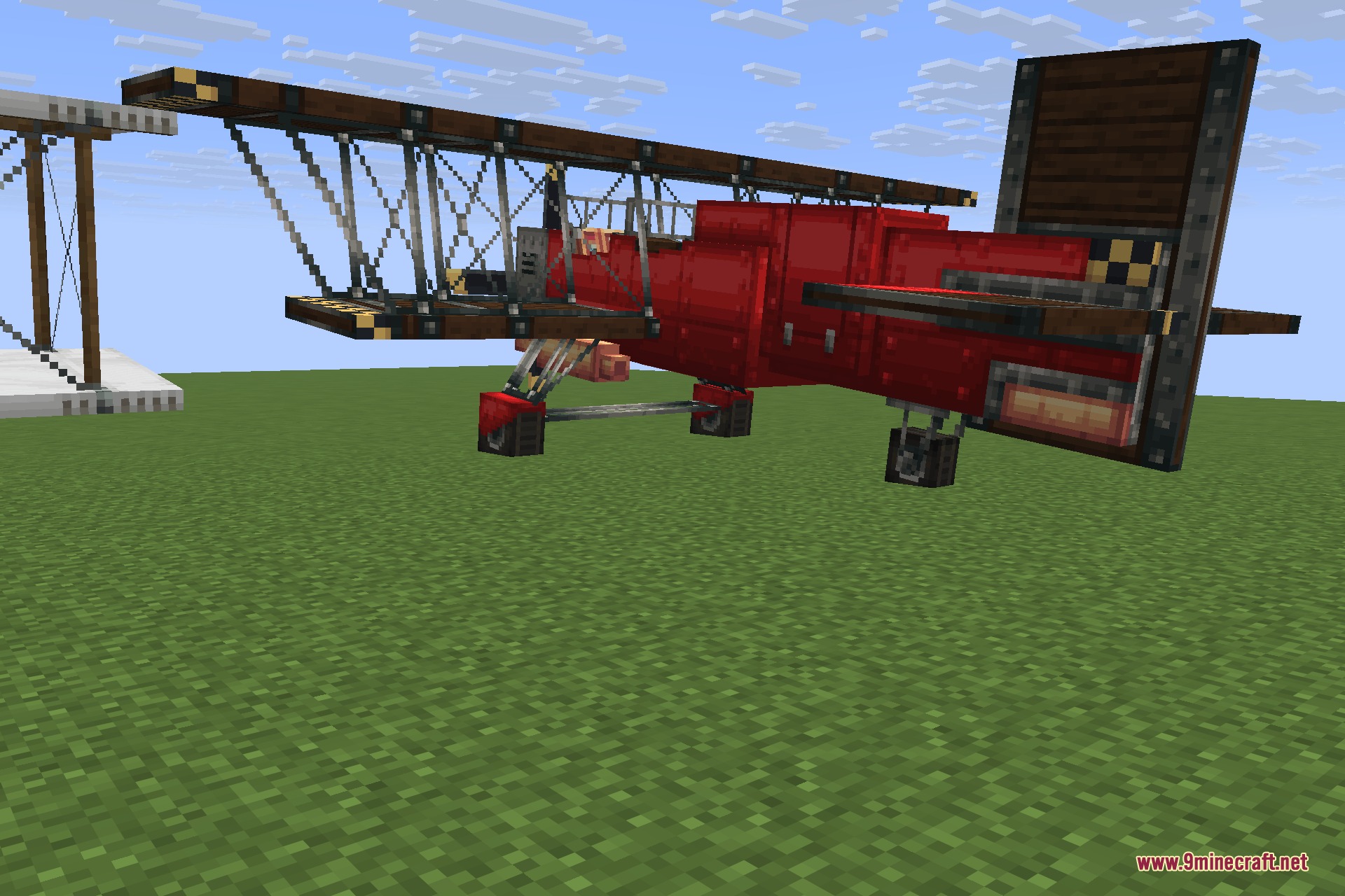 Man of Many Planes 9minecraft Mod Screenshot 3 A bright red scarlet biplane parked on a flat green grass field