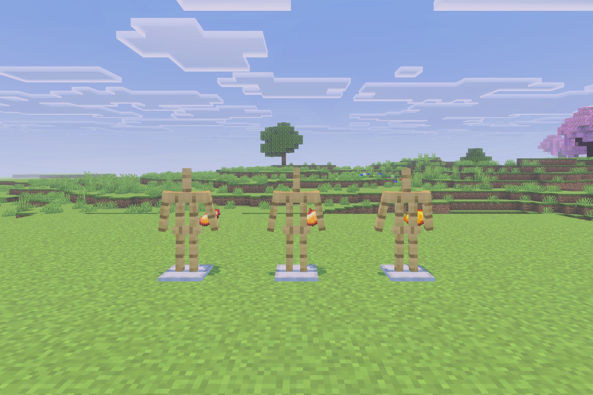 My Totem Doll 3d Texture Pack Screenshot 3 Three armor stands holding miniature 3D player dolls in a grassy field