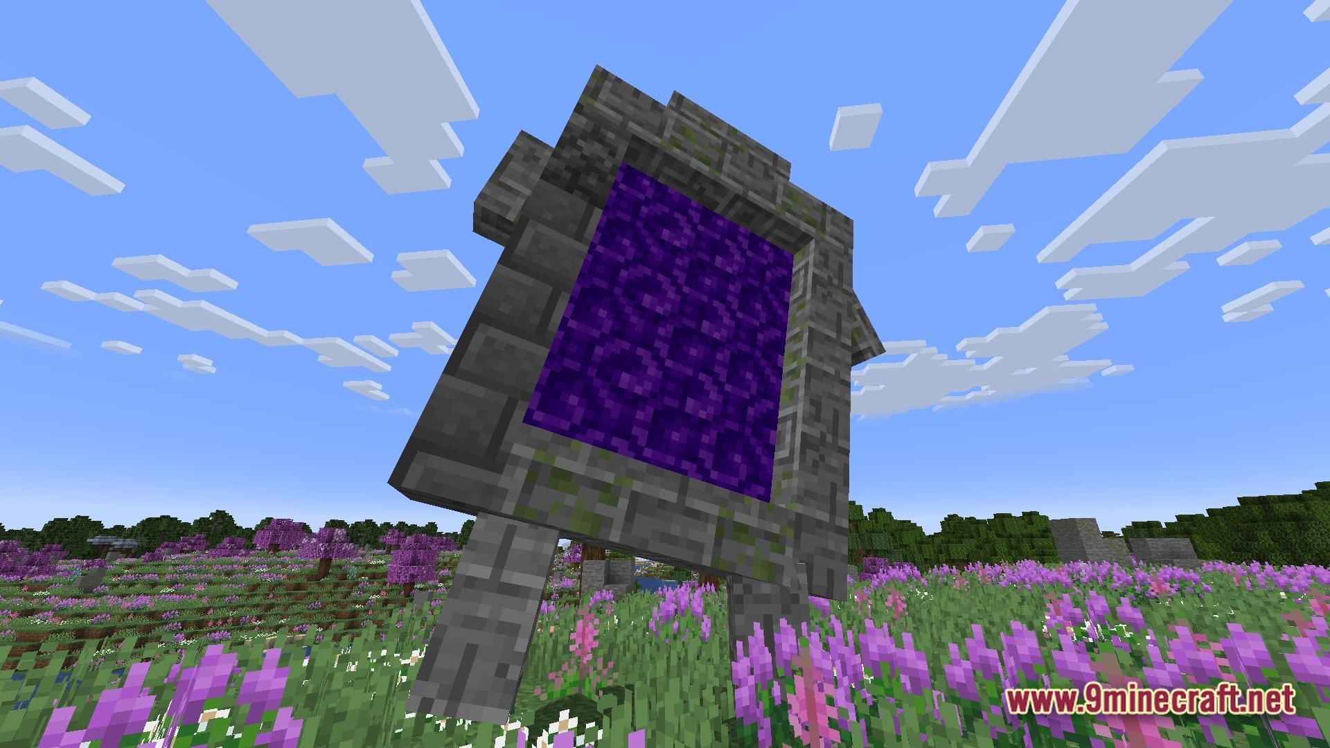 A large stone portal stands in a flowery meadow under a clear blue sky