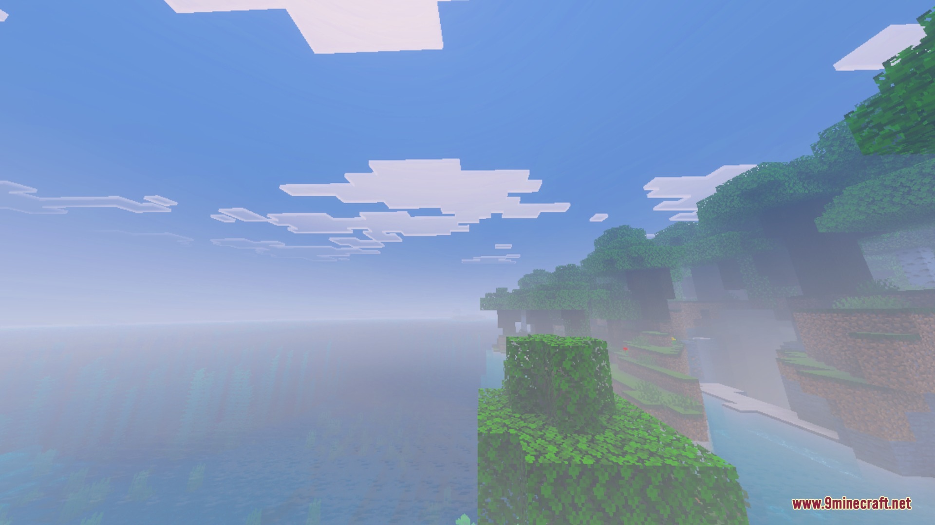 Nebux Visuals Shader Screenshot 2 Green trees and grass on a cliff overlooking a foggy Minecraft ocean