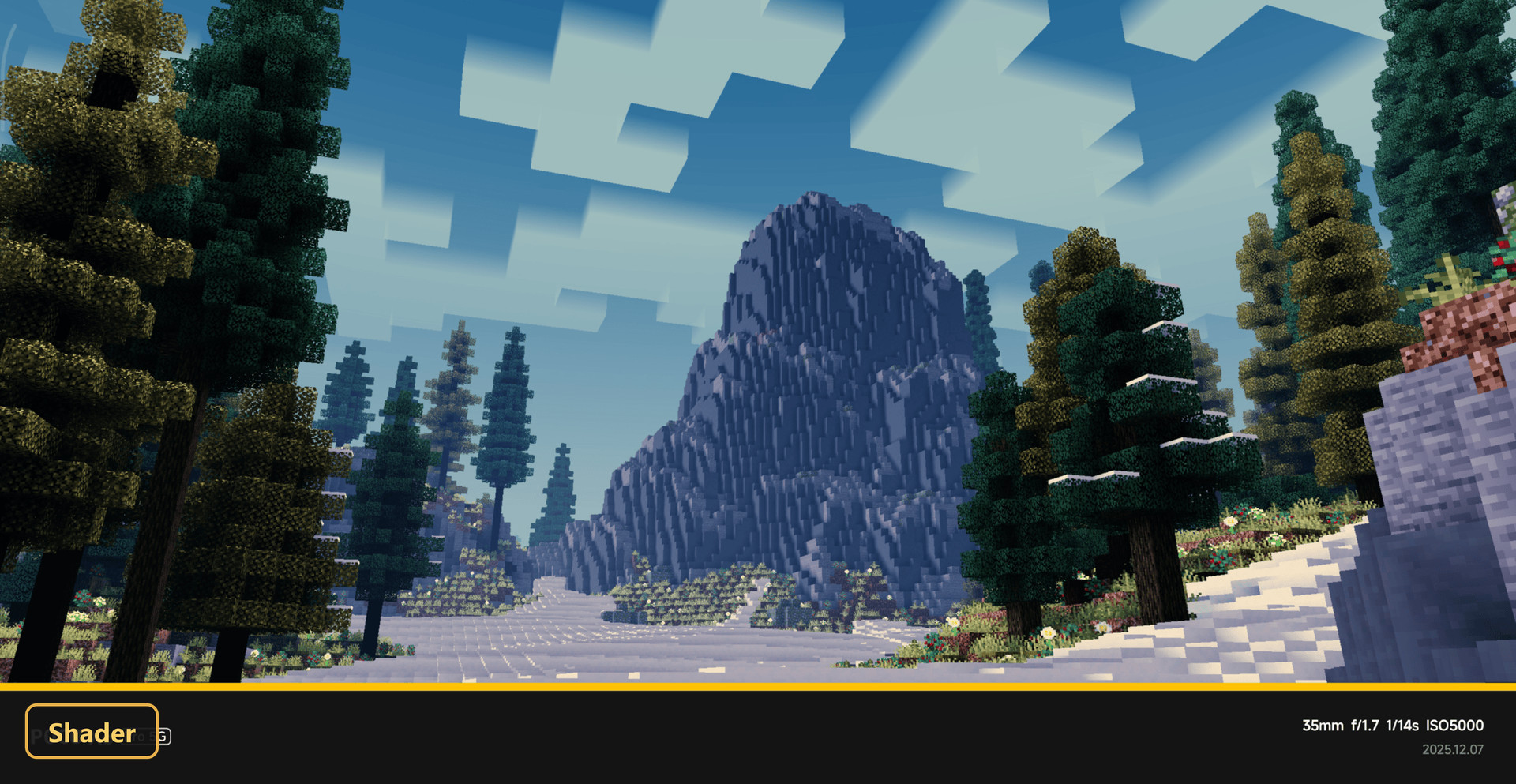 Snowy mountain landscape with pine trees under a blue sky