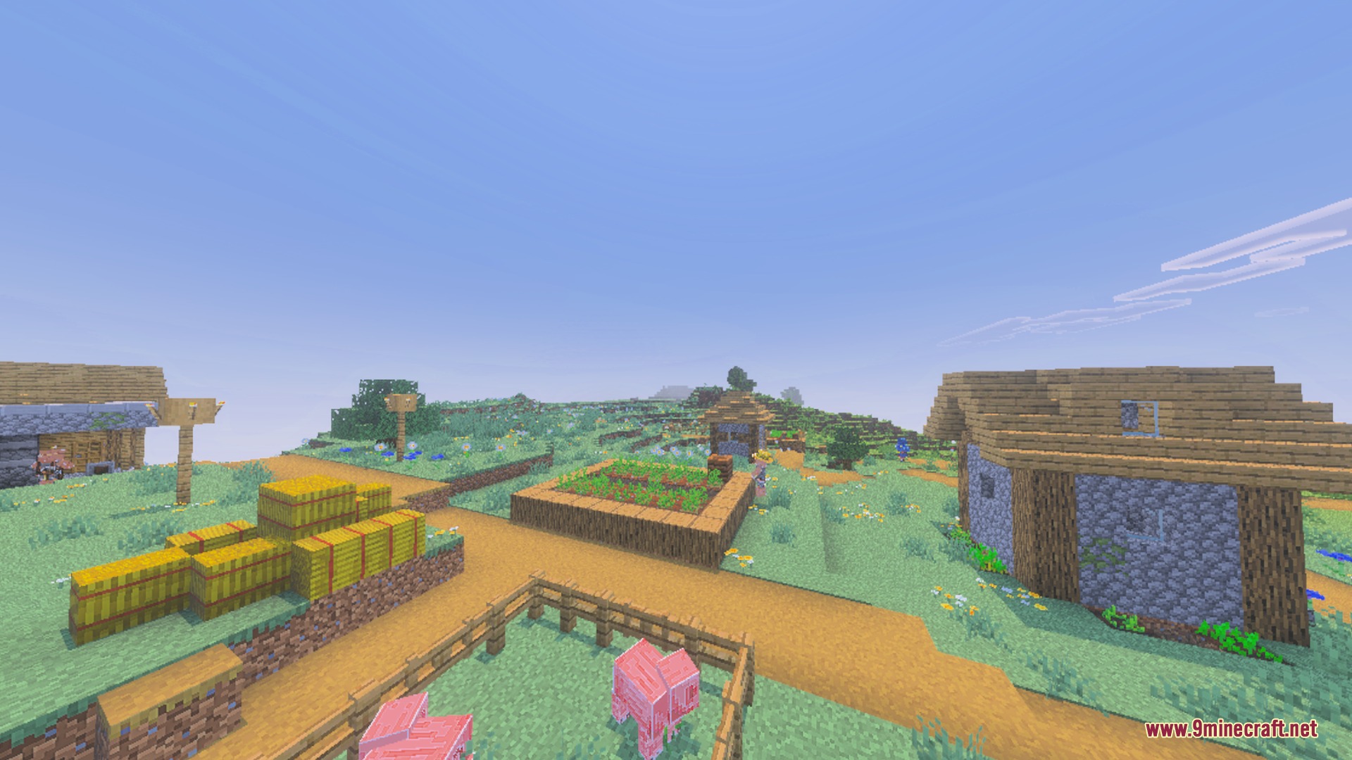 A bright Minecraft village featuring hay bales and a small wooden farm