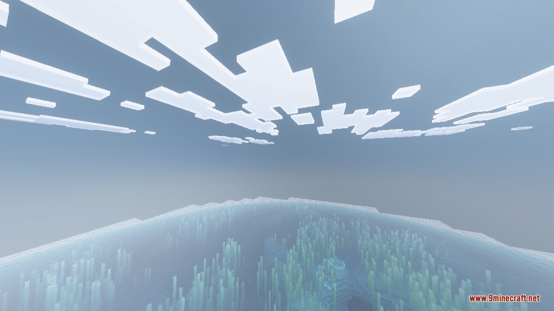 Clear ocean water under a bright sky with blocky clouds and underwater plants