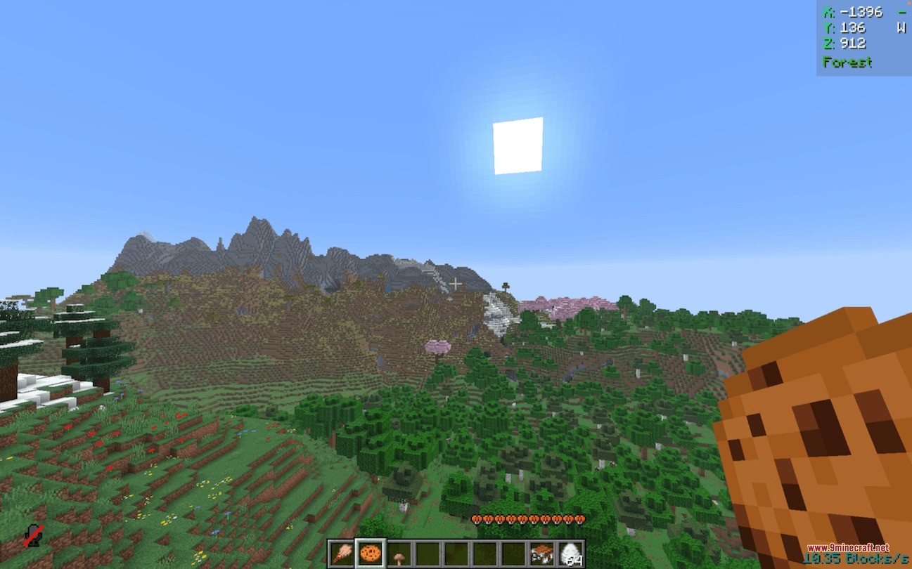 First person view of a player holding a cookie overlooking a mountain landscape