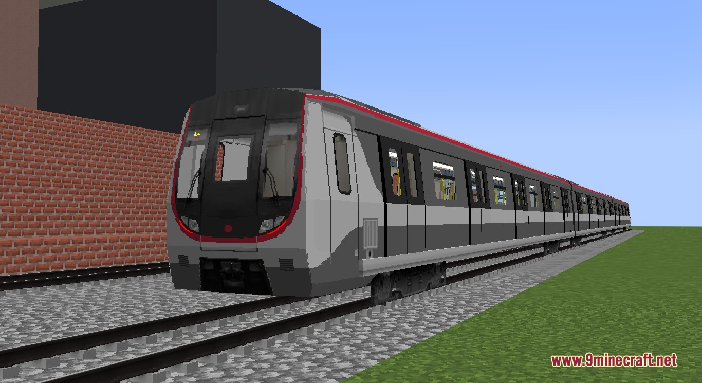 A long modern metro train with red accents on a gravel track