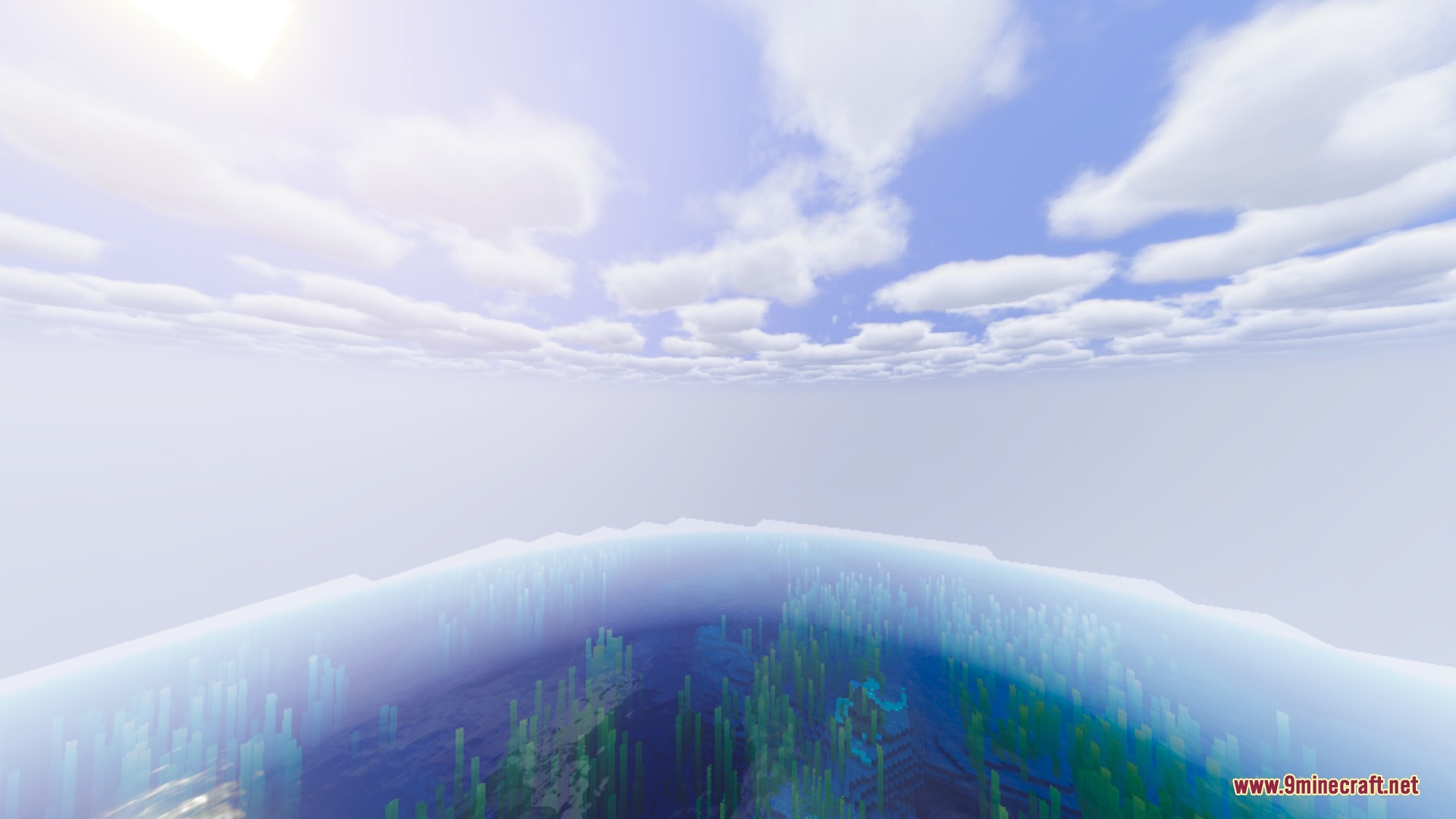 Vast blue ocean with kelp visible underwater under a bright cloudy sky