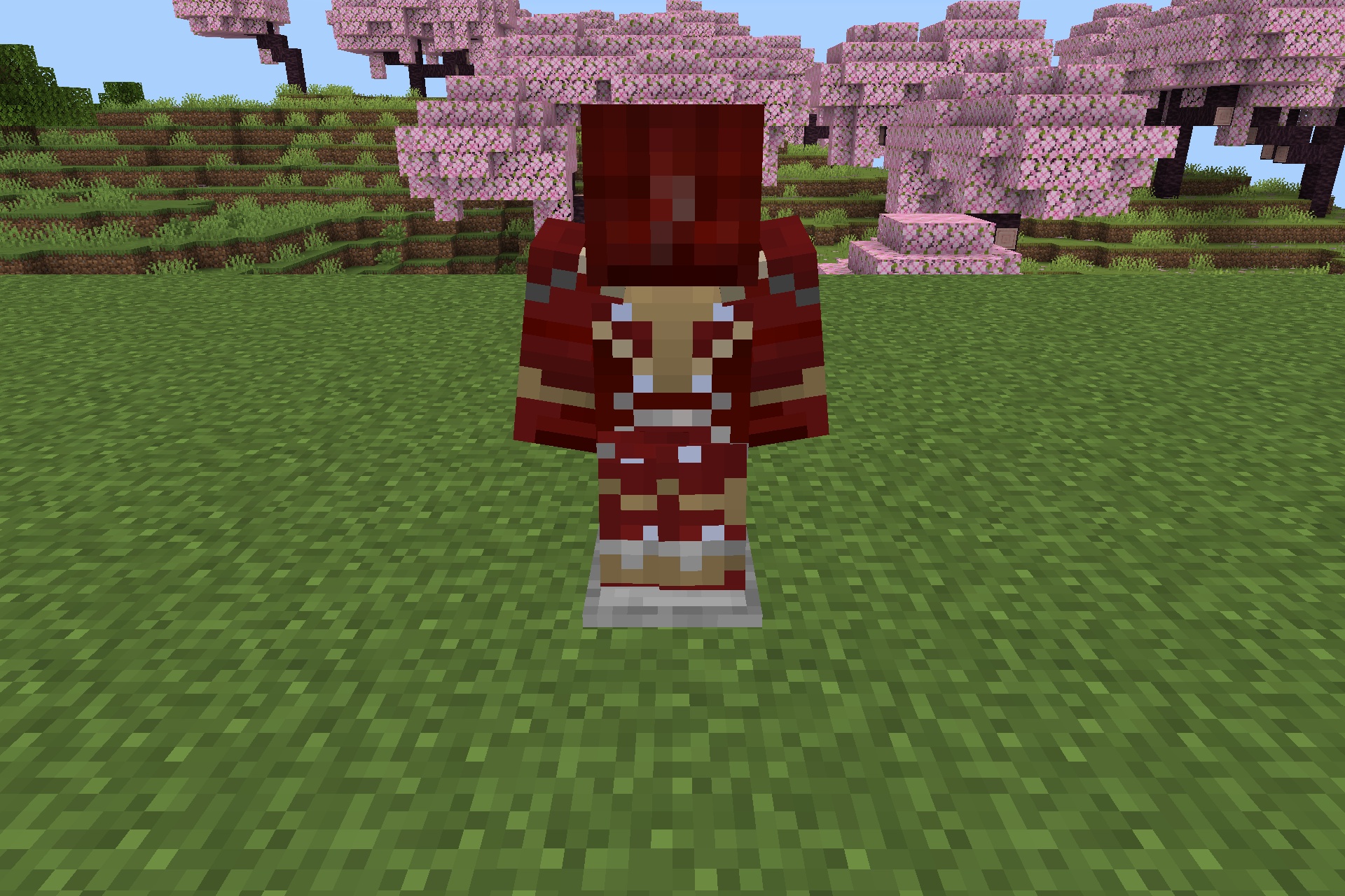 Red and gold superhero armor displayed on a stand in a cherry blossom biome
