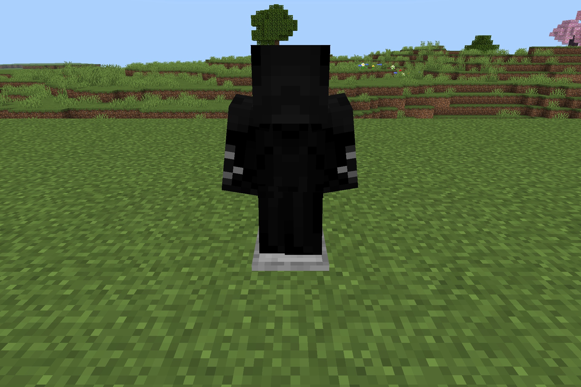 A sleek black superhero suit displayed on an armor stand in Minecraft
