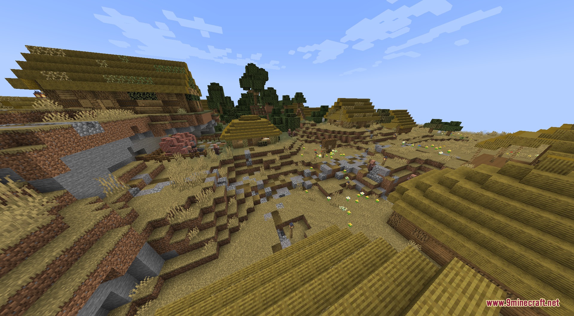 A small Minecraft village in a savanna biome with hay bale roofs