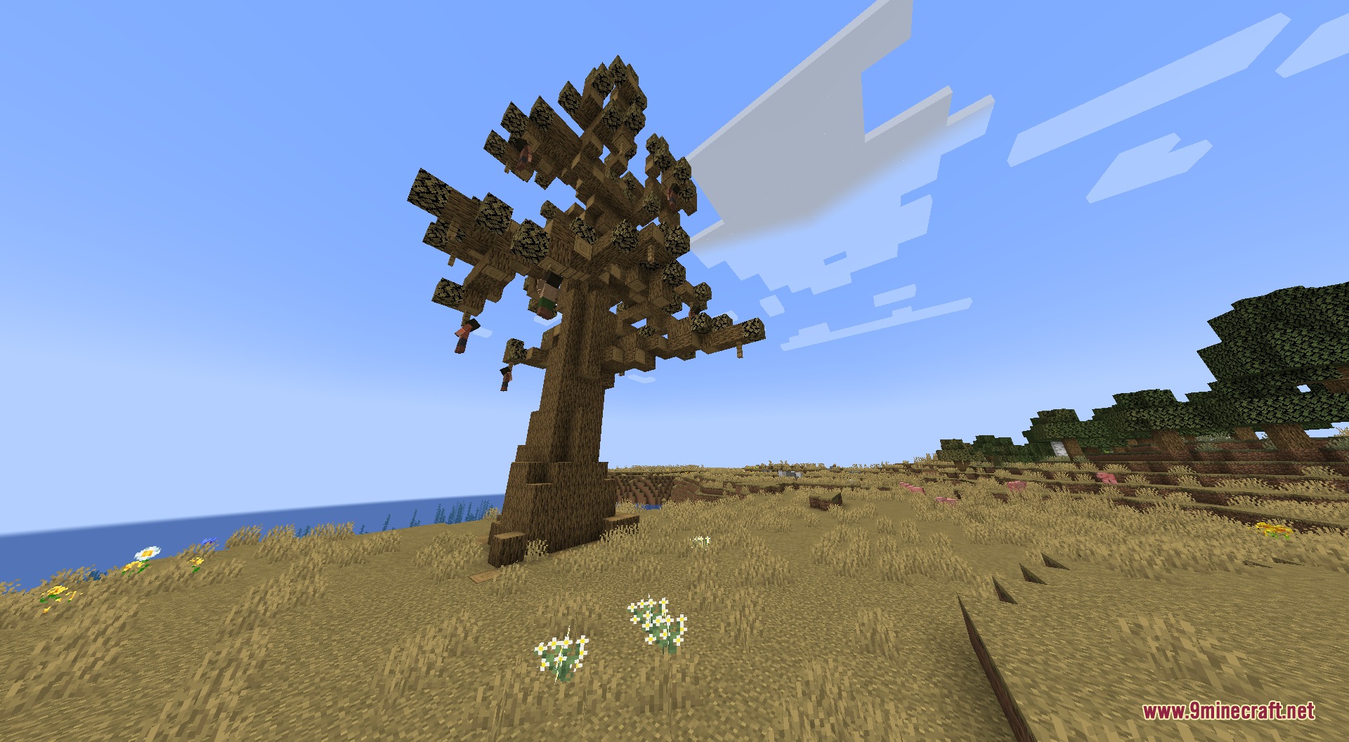 A large custom tree stands in a dry savanna biome under blue skies