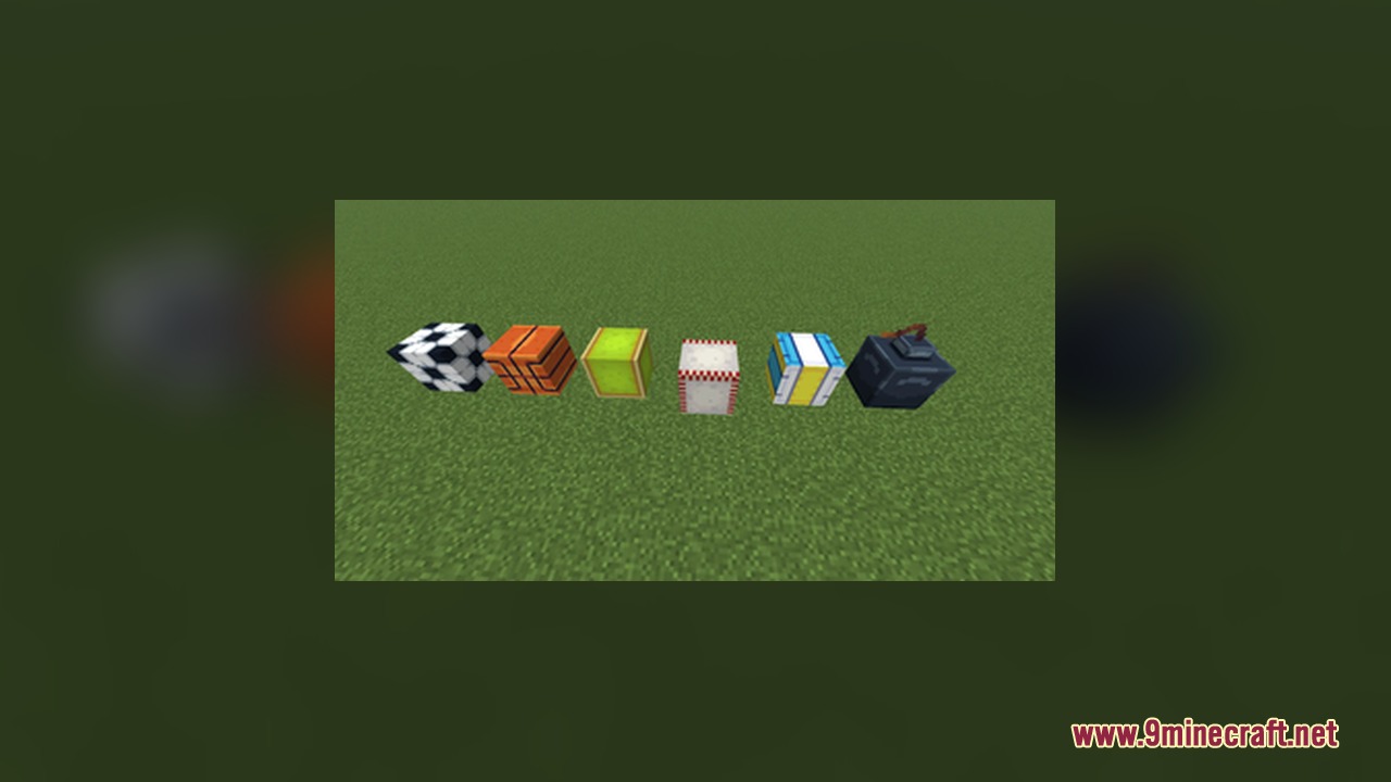 Various sports balls and a bomb model displayed on the green grass