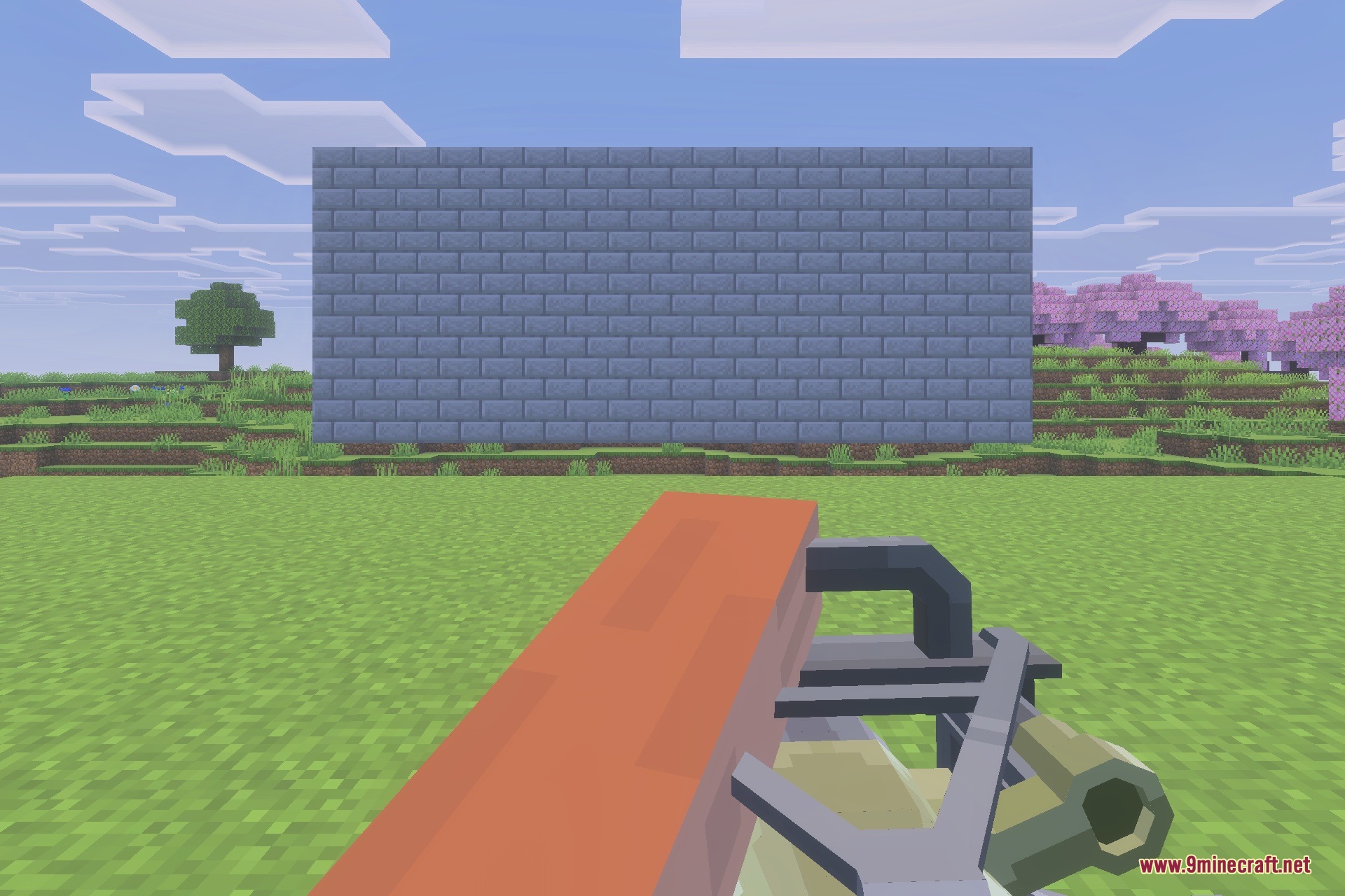 Player aiming a TACZ mod heavy firearm at a stone wall