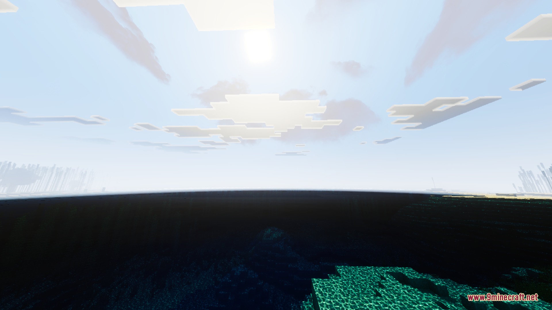 Bright sunlight reflects off the ocean surface under a clear blue sky