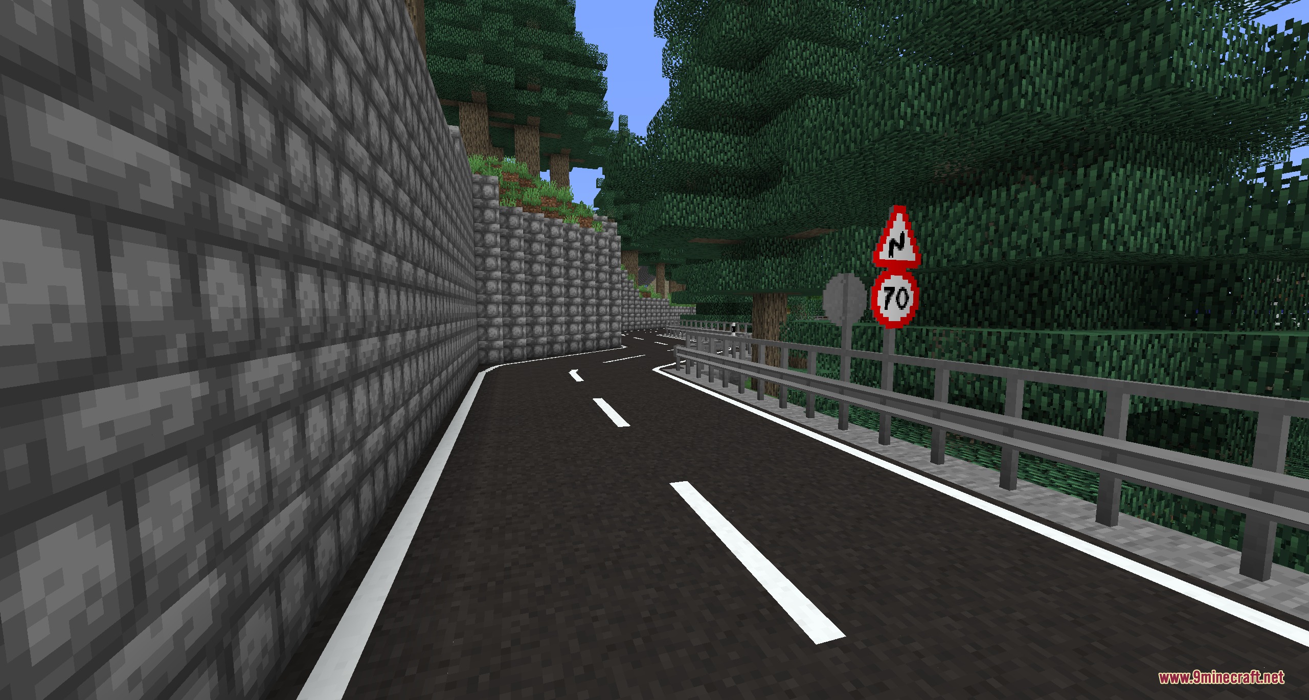 Urban Asphalt Grid Mod Screenshot 5 A winding asphalt road with traffic signs and a grey stone wall