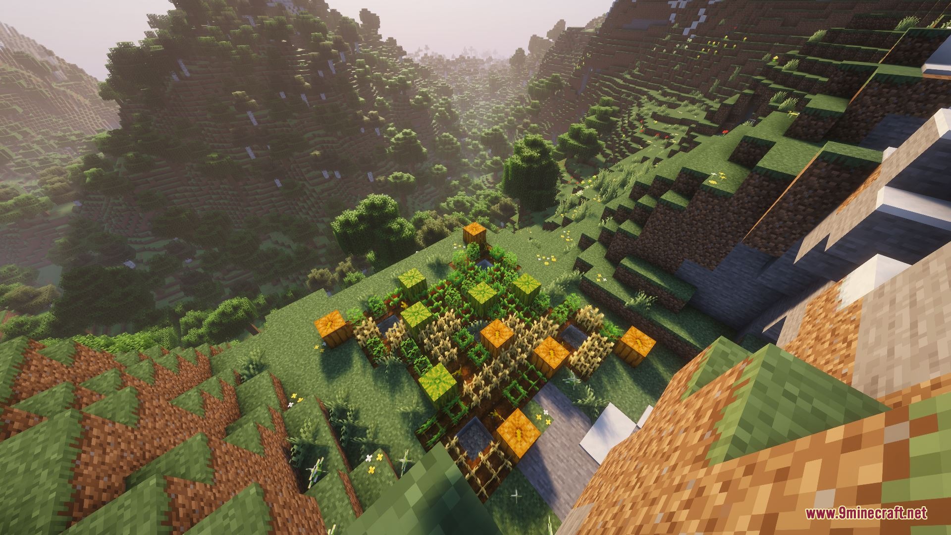 A small farm with pumpkins and wheat nestled in a lush mountain valley