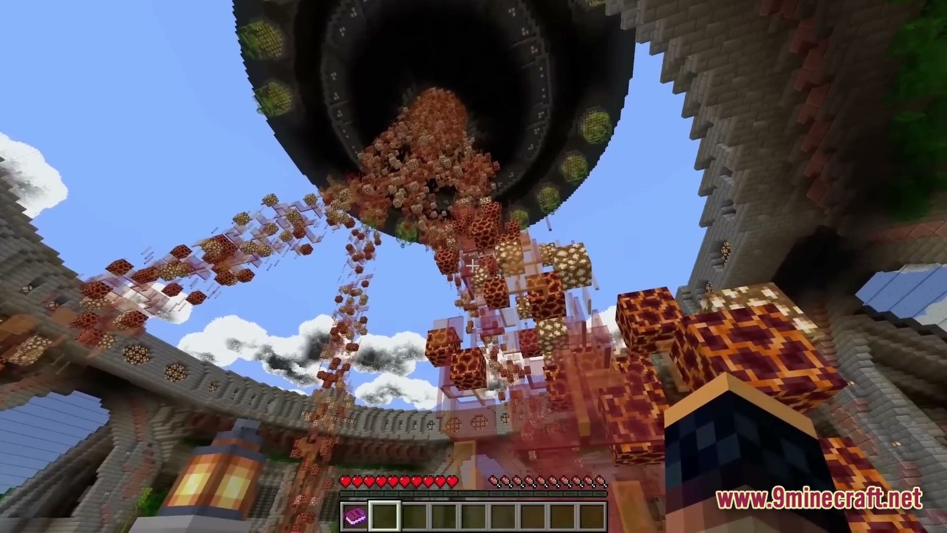 A large circular structure in the sky releases a stream of magma and glowstone blocks downward
