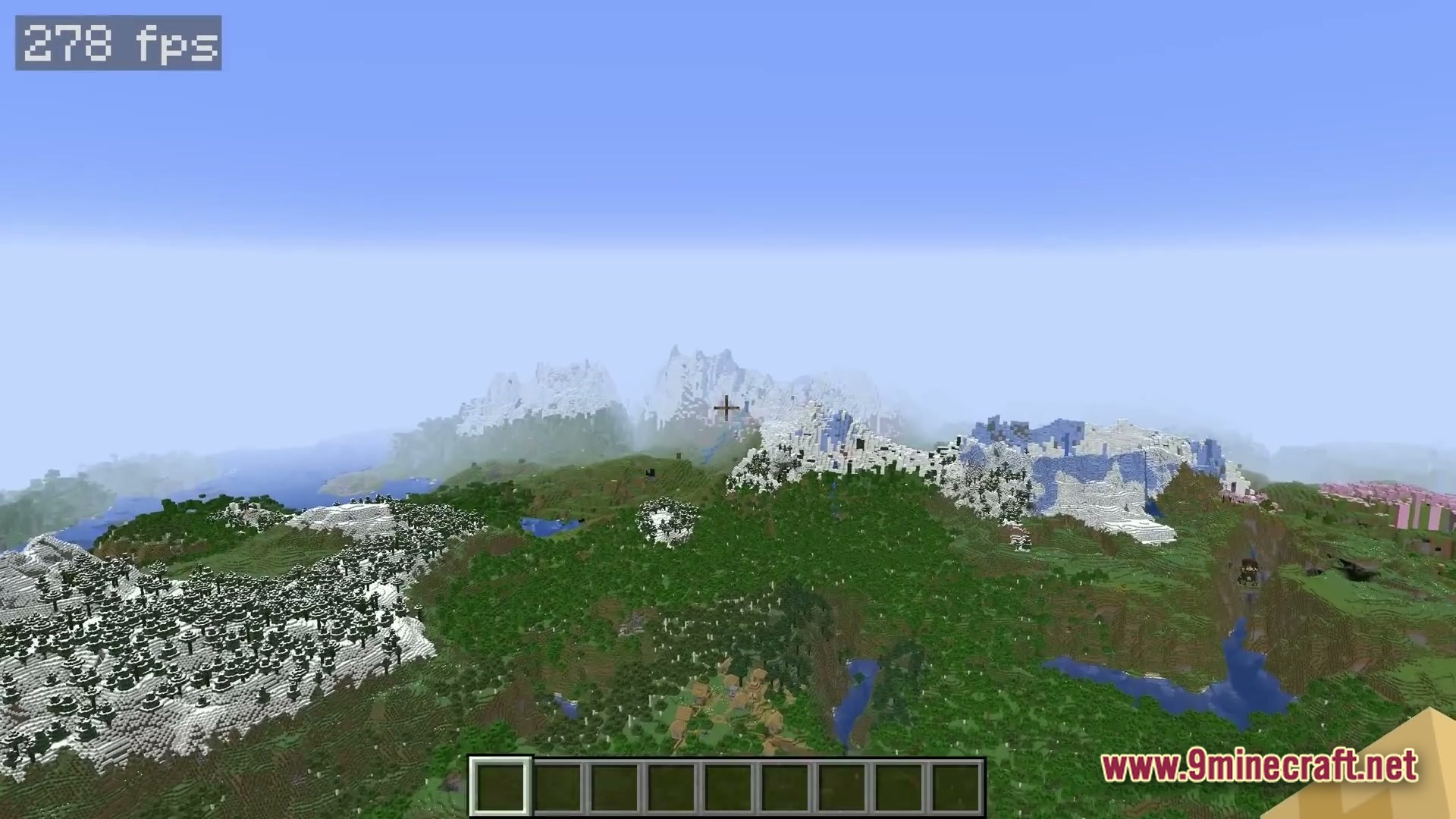A high-altitude view of snow-capped mountains, dense forests, and a small village in a Minecraft world