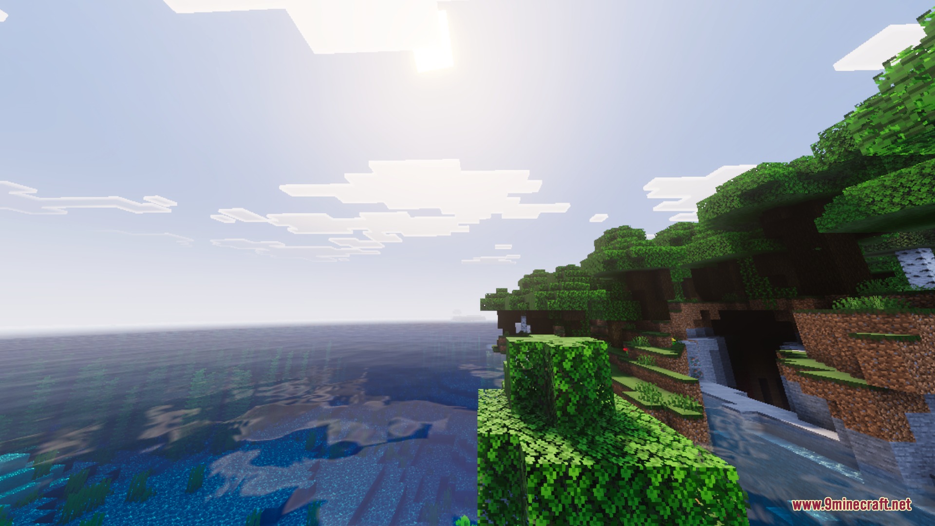 Vibrant Legacy L Espace Shader Screenshot 2 Lush green trees on a cliff overlooking a bright blue ocean in Minecraft
