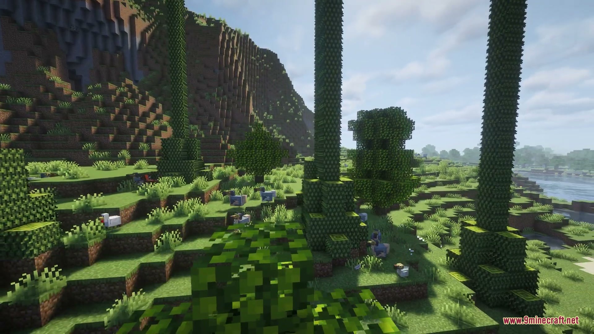 Wilderbound Frontiers Mod Screenshot 7 Prehistoric creatures from Wilderbound Frontiers Mod roaming a lush green Minecraft landscape