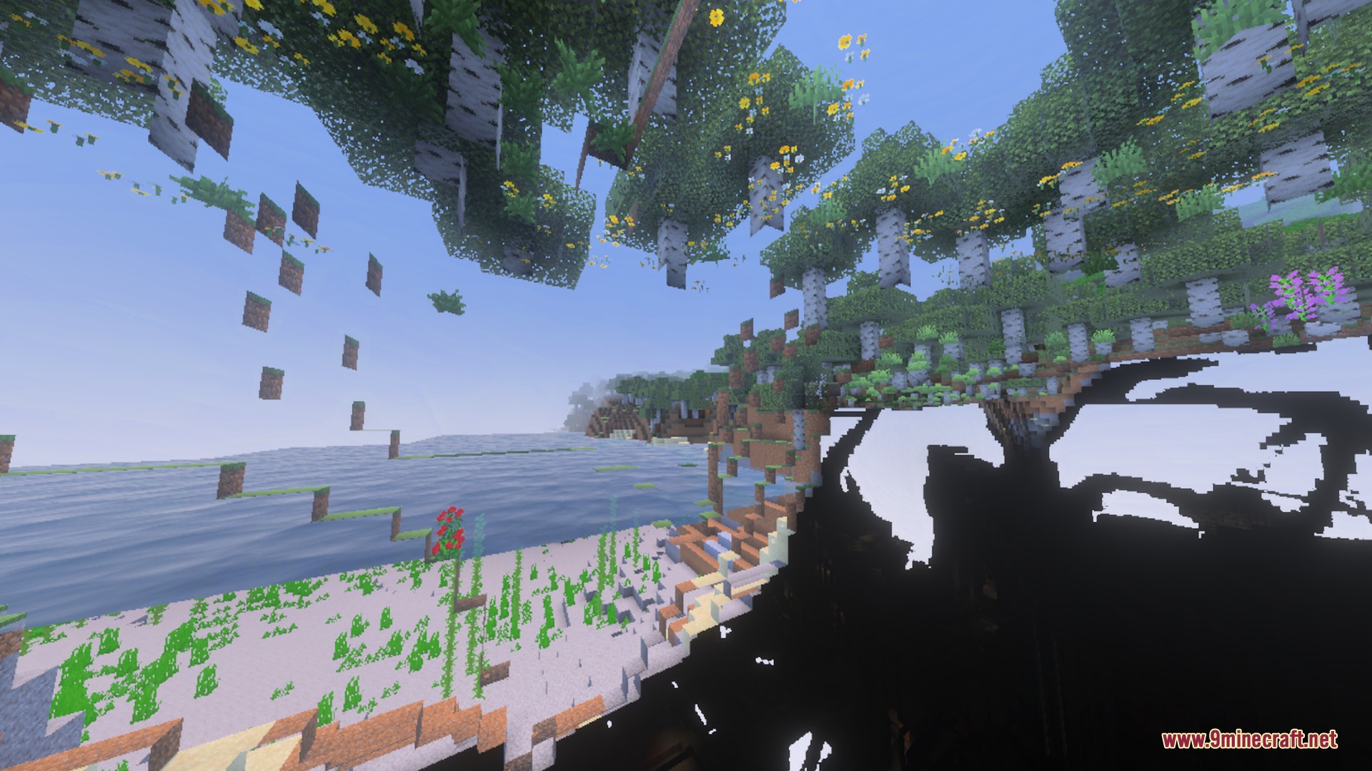Crystal clear water reveals the seabed and birch trees on the grassy shore