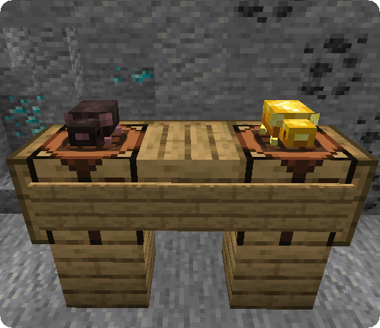 Two rats, one brown and one golden, on a crafting table.